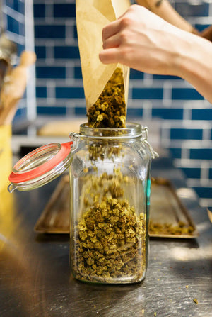 CBD hemp buds/flowers being poured from a bag in to a mason jar