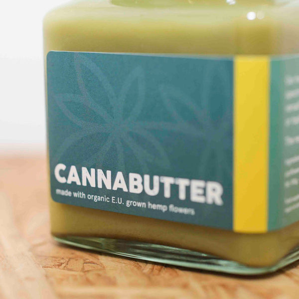 An angled photo of the front of a jar of Little Collins CBD Cannabutter