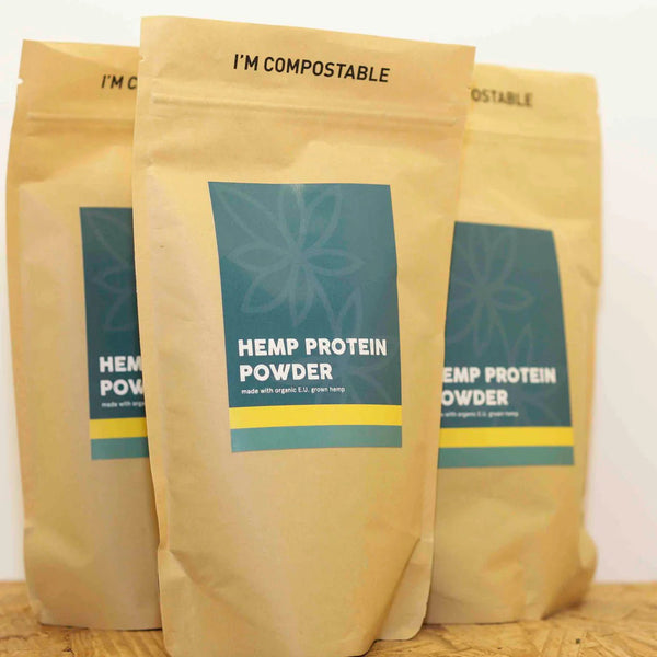 Three bags of Little Collins Hemp Protein Powder stacked side by side showing front labels and eco packaging.