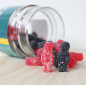 CBD oil bottle beside CBD gummies jar from Little Collins