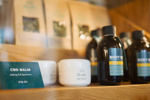 CBD body oil and CBD balm on a gym towel, representing natural muscle recovery products from Little Collins CBD.