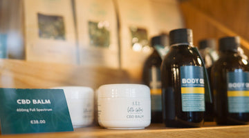 CBD body oil and CBD balm on a gym towel, representing natural muscle recovery products from Little Collins CBD.