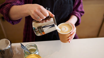 Milk being poured in to a cup of CBD Coffee