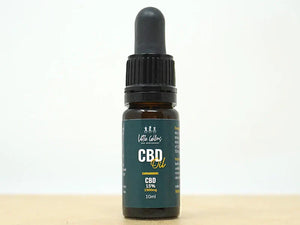 Full-spectrum CBD oil bottle beside hemp leaves and a dropper