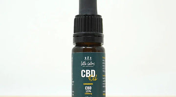 Full-spectrum CBD oil bottle beside hemp leaves and a dropper