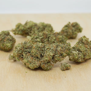 Close-up of Genesis Kush CBG buds on a wooden table at Little Collins CBD Dispensary Ireland, highlighting the light green hues and trichome detail of premium CBG flower.