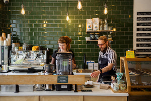 Two baristas preparing Hemp CBD Tea behind the counter at Little Collins CBD Dispensary.