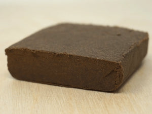 Flat block of OG Brown CBD Hash on a table