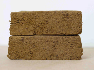 Two pieces of Cookie Dough CBD Hash stacked on one another.