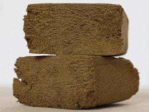 Two pieces of CBD Hash stacked on top of each other.