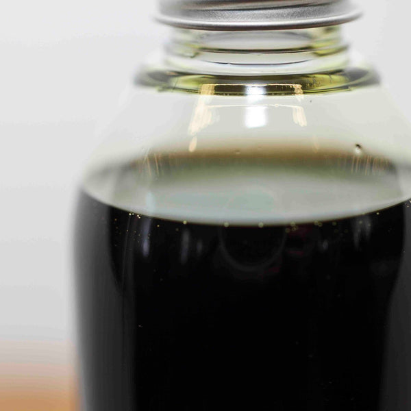 Close-up of a bottle of CBD oil for dogs with a dark liquid on a blurred background
