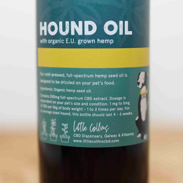Bottle of CBD Hound Oil for dogs with organic E.U. grown hemp on a wooden surface.